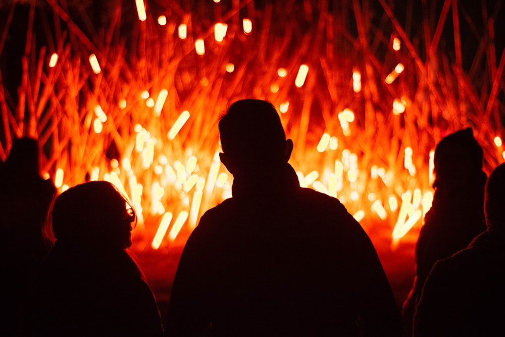 a group of people standing in front of a fire