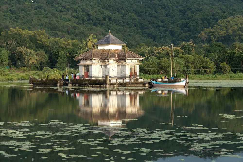 a house on the water with a boat in front of it