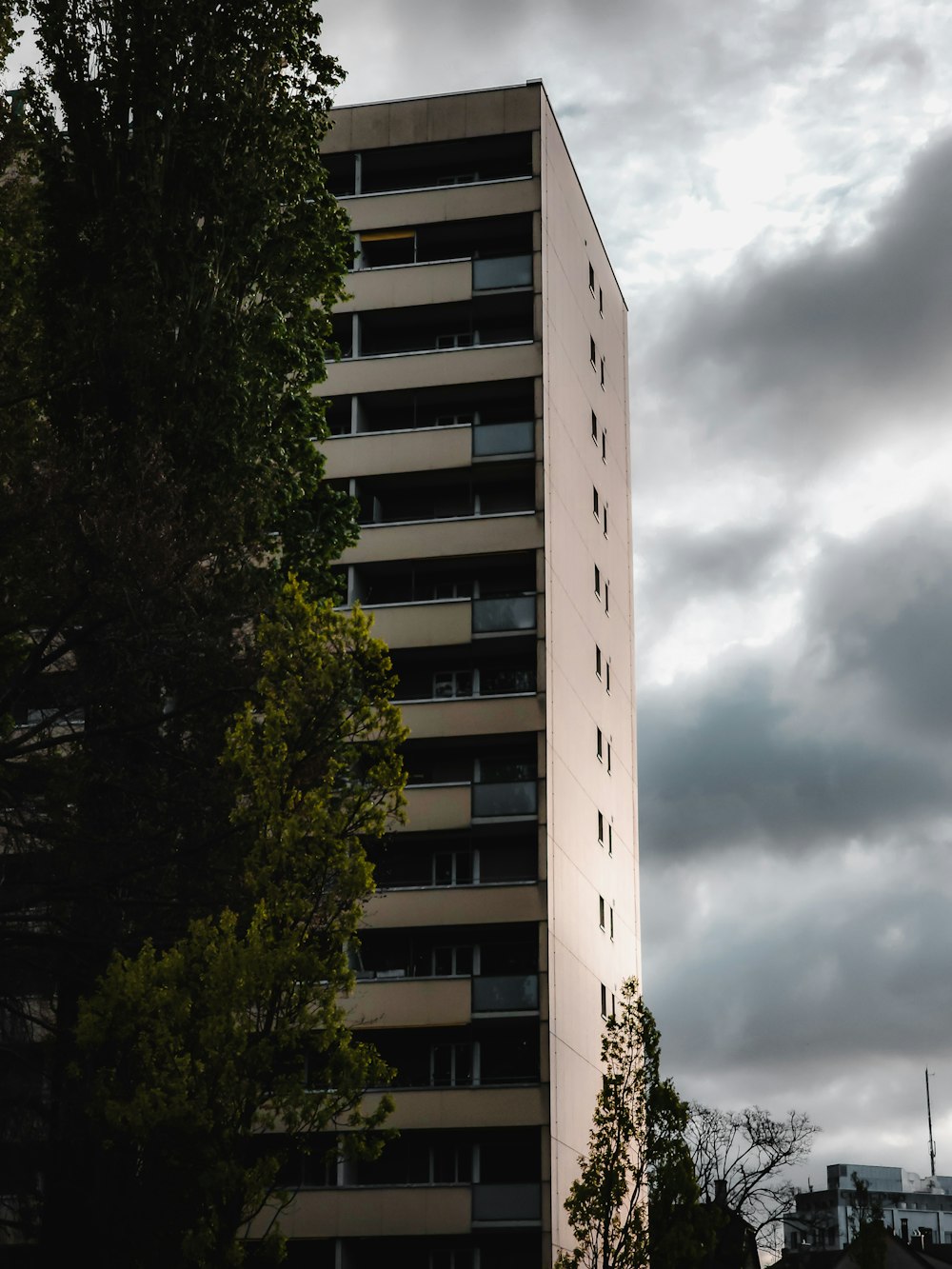 a tall white building with balconies on top of it