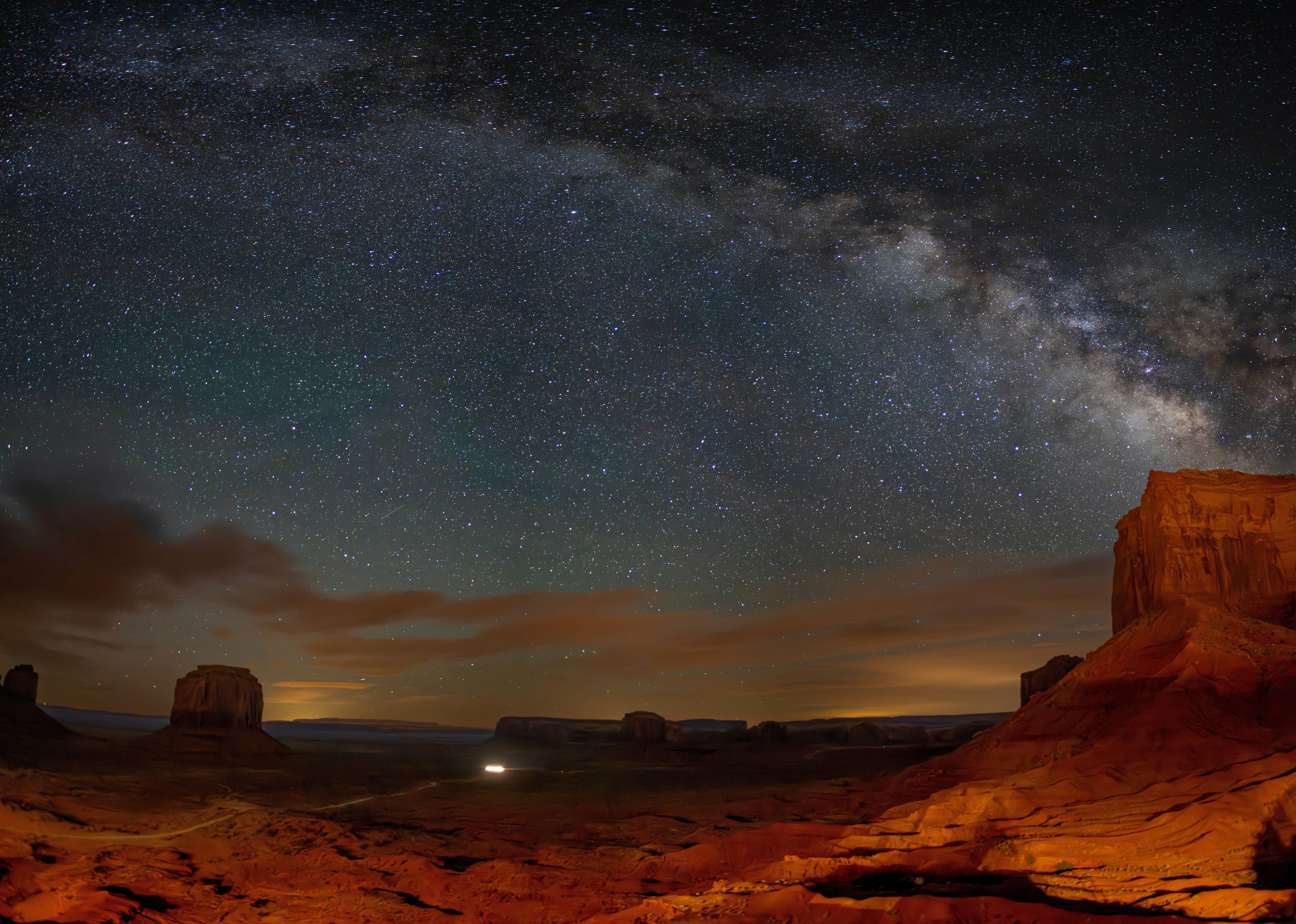 the night sky is filled with stars above a desert landscape