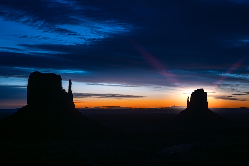 the sun is setting over the mountains in the desert