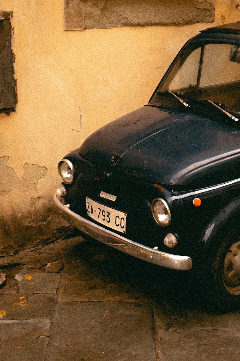 a small black car parked next to a building