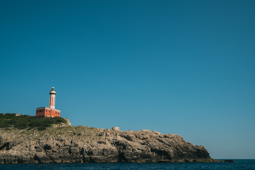 a lighthouse on top of a rocky outcropping