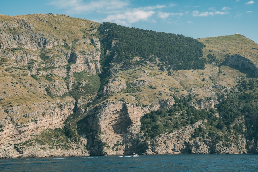 a boat on a body of water near a mountain