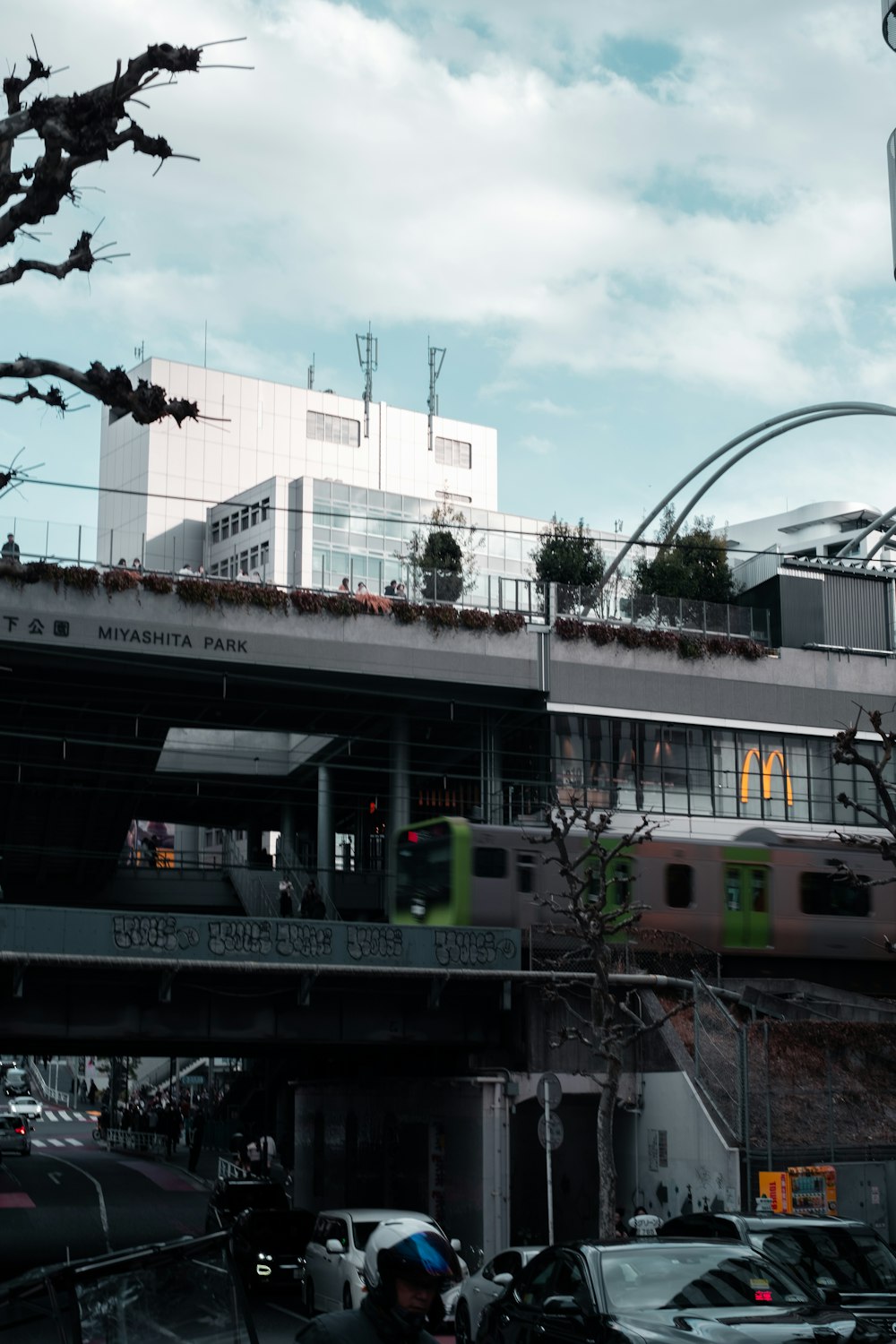 a city street filled with lots of traffic under a bridge