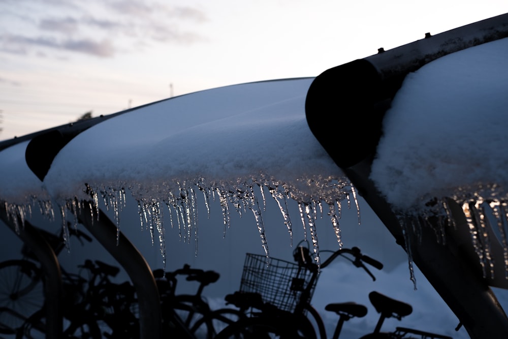 a row of parked bicycles covered in snow