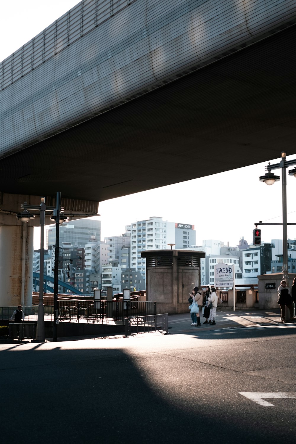 a group of people walking under a bridge