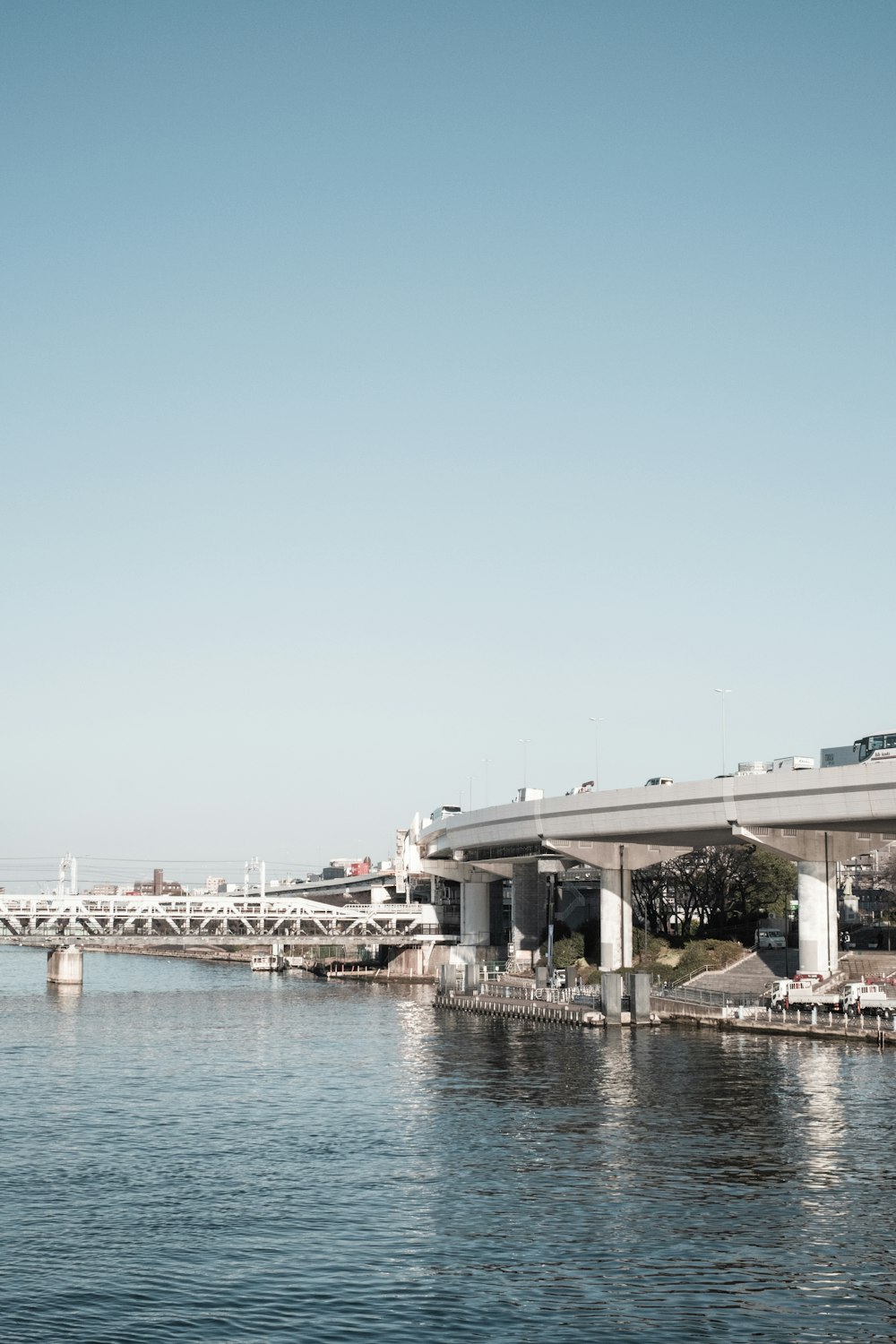 a bridge over a body of water with a train on it