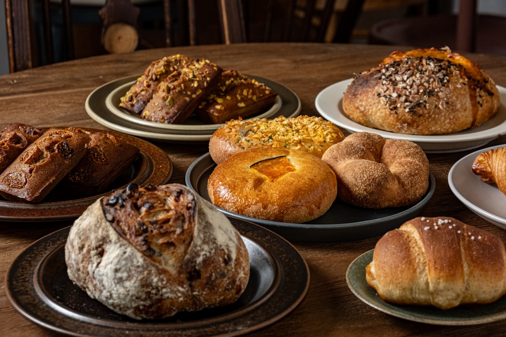 a table topped with lots of different types of bread