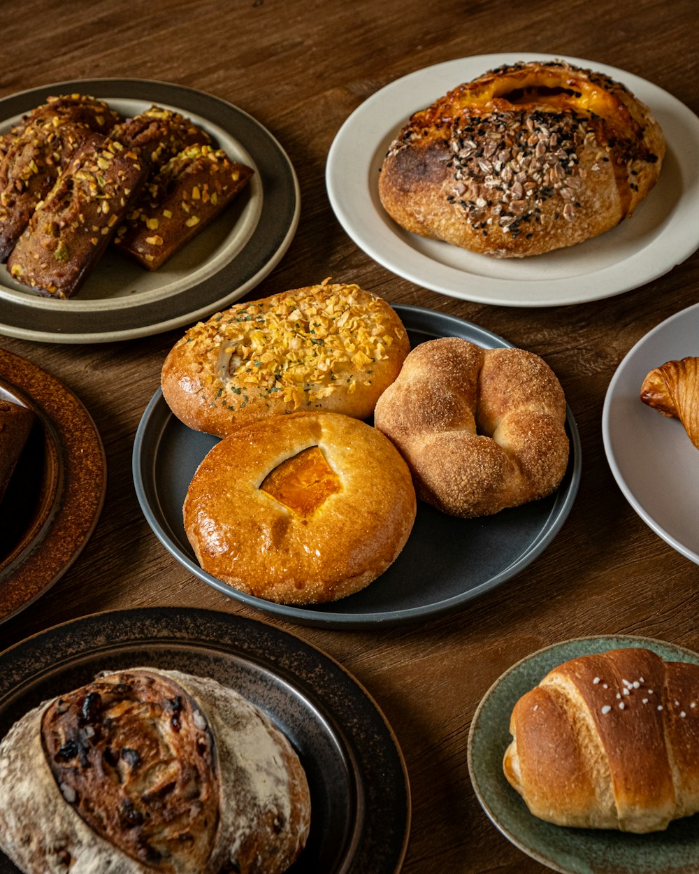 a wooden table topped with plates of pastries