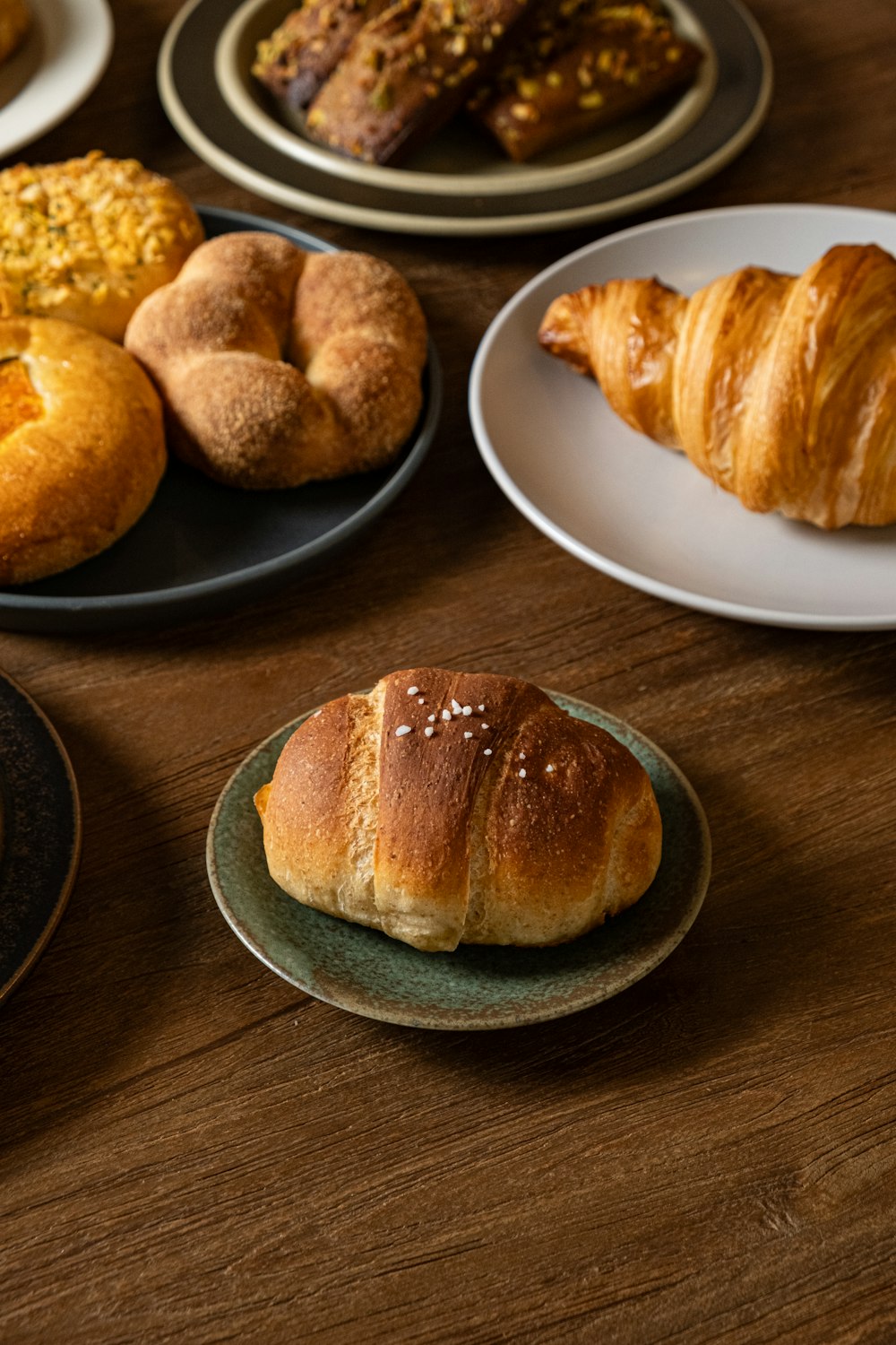 a wooden table topped with different types of pastries