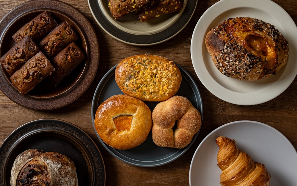 a wooden table topped with plates of pastries