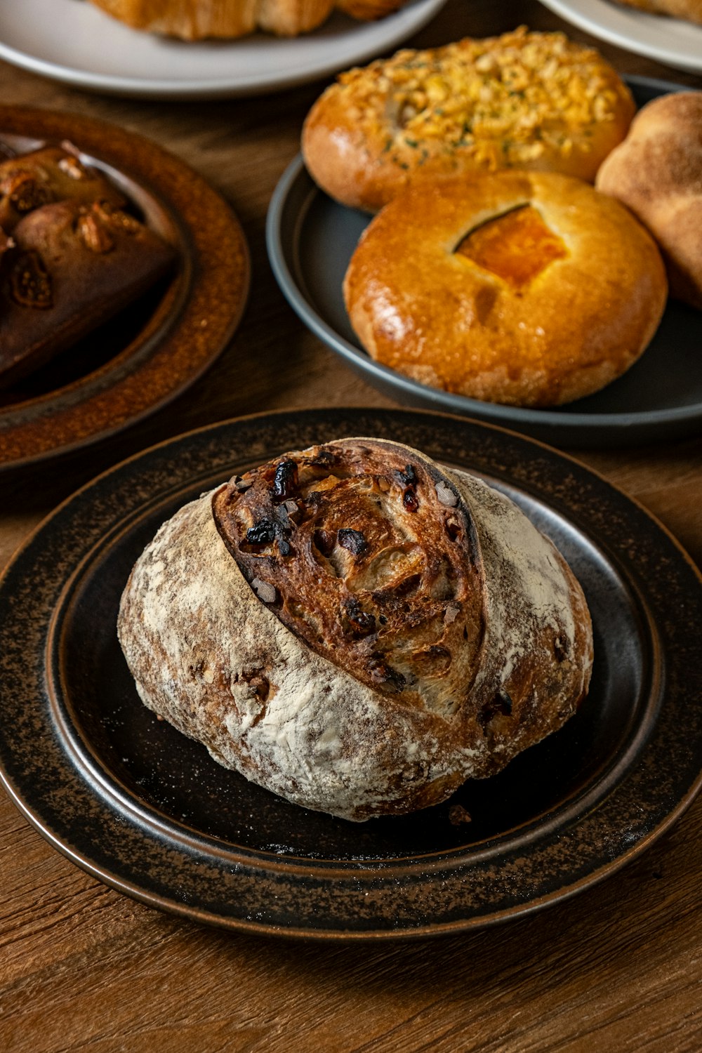 a table topped with plates of bread and pastries