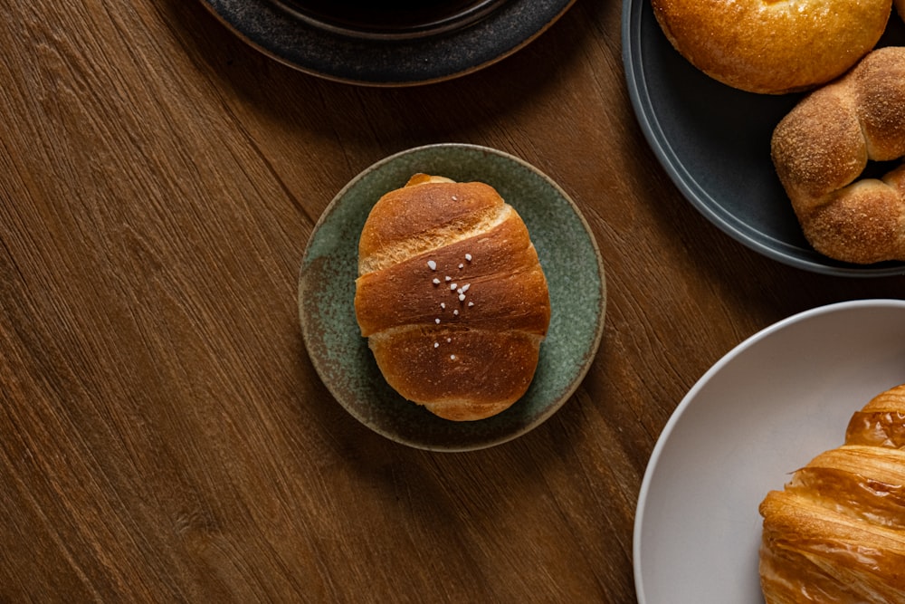 a wooden table topped with plates of pastries