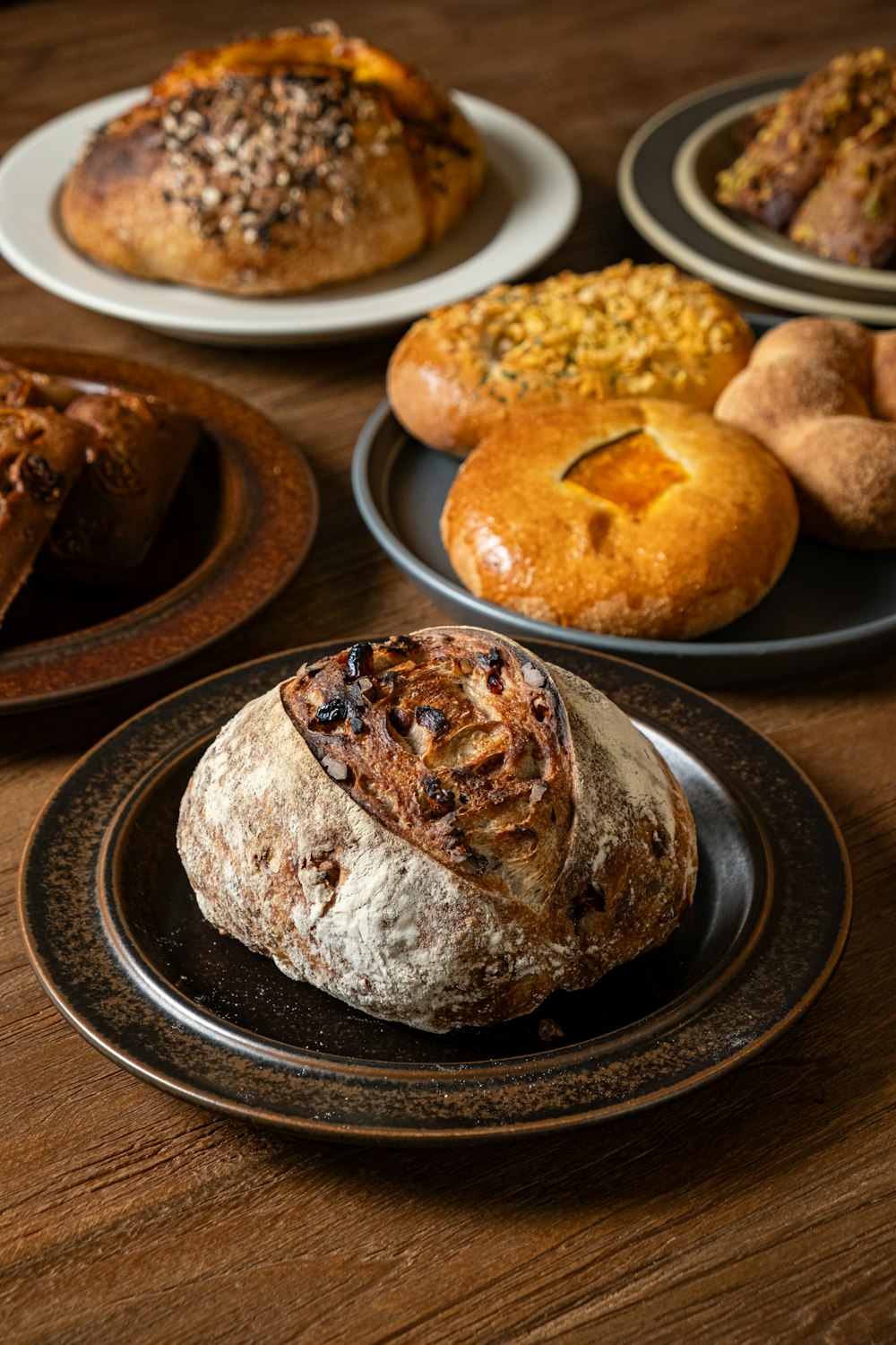 a wooden table topped with plates filled with bread