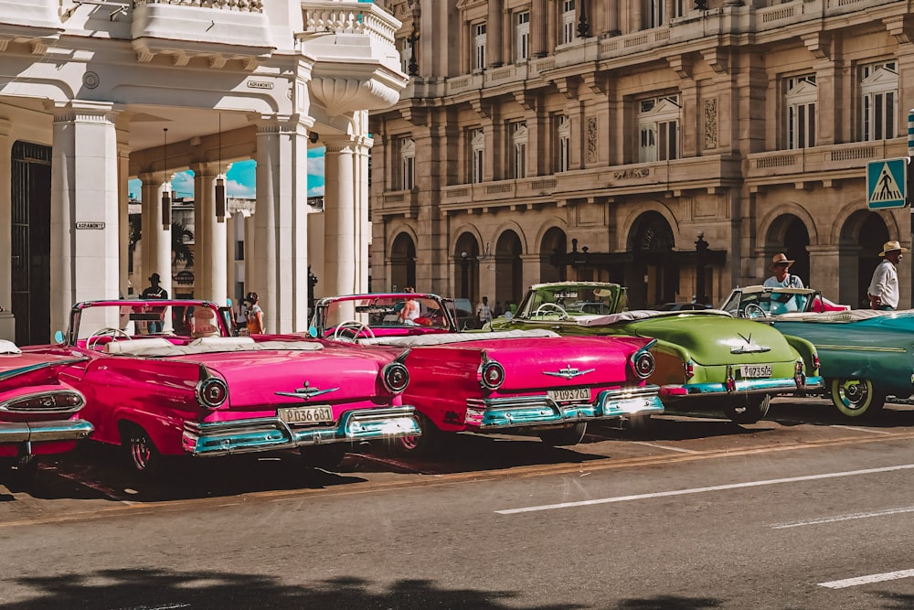 a row of classic cars parked on the side of the road