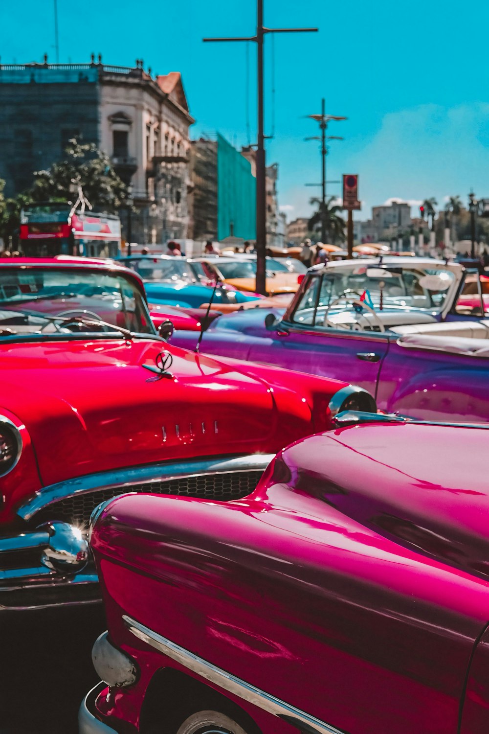 a row of classic cars parked in a parking lot