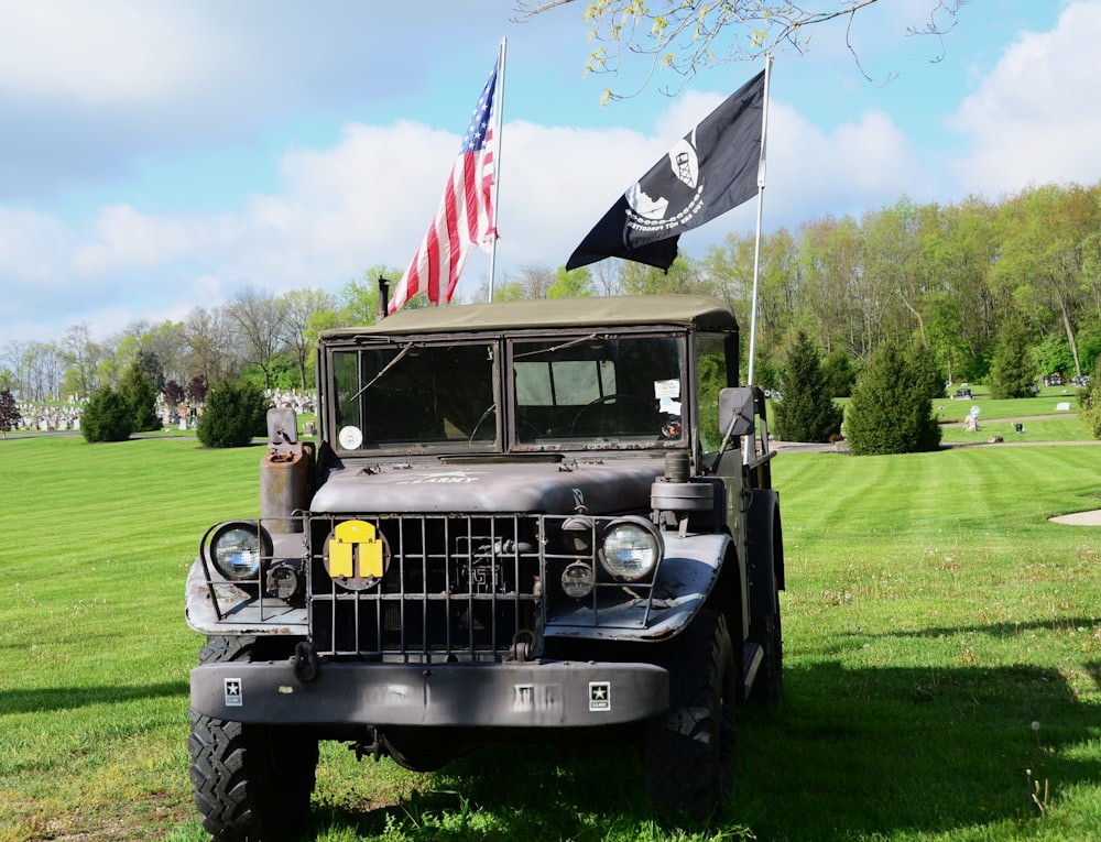 an old military truck with a flag on top of it