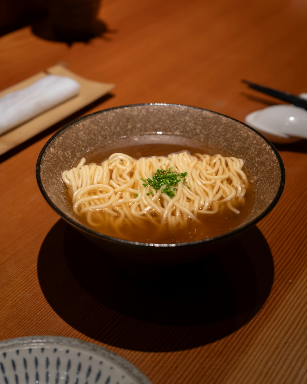 a bowl of noodles with a garnish on top of it