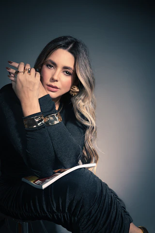 a woman sitting on top of a chair holding a book