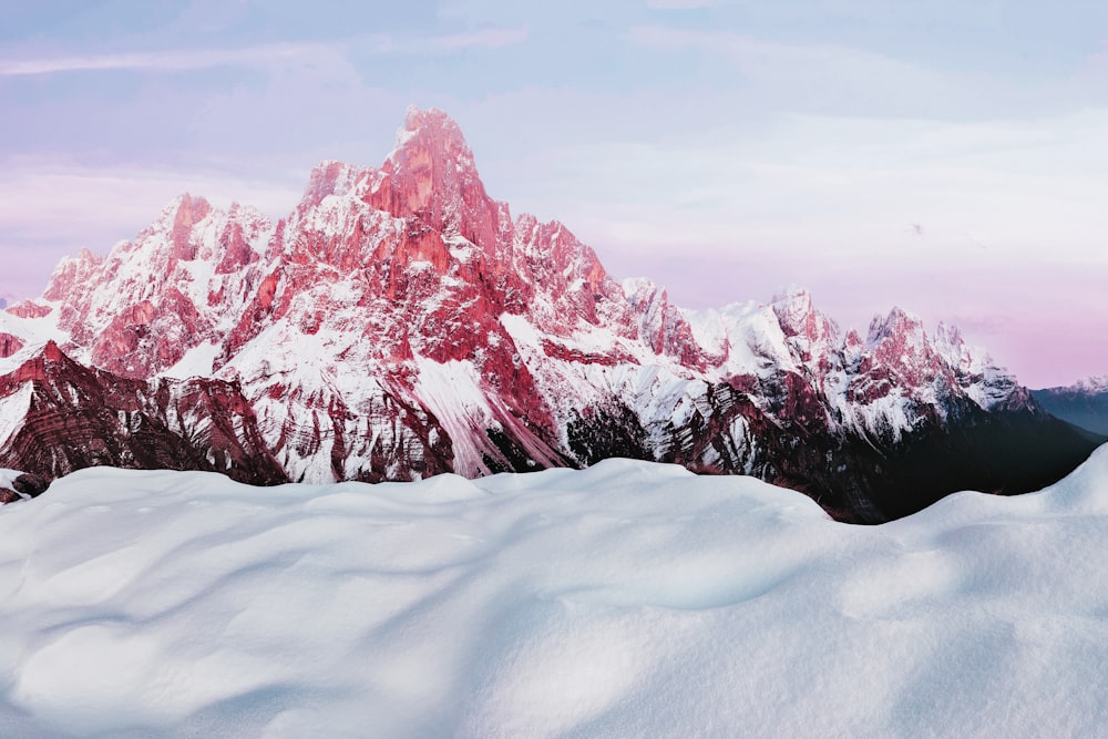 a snow covered mountain with a pink sky in the background