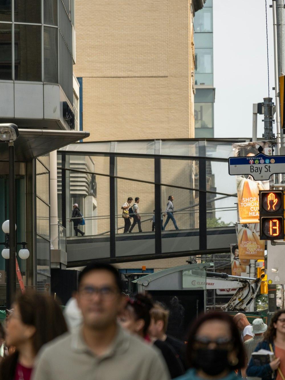 a group of people walking down a street next to tall buildings