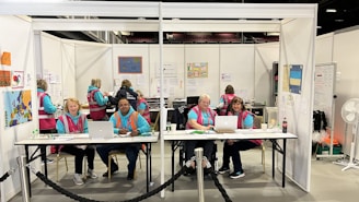 a group of people sitting at a table with laptops