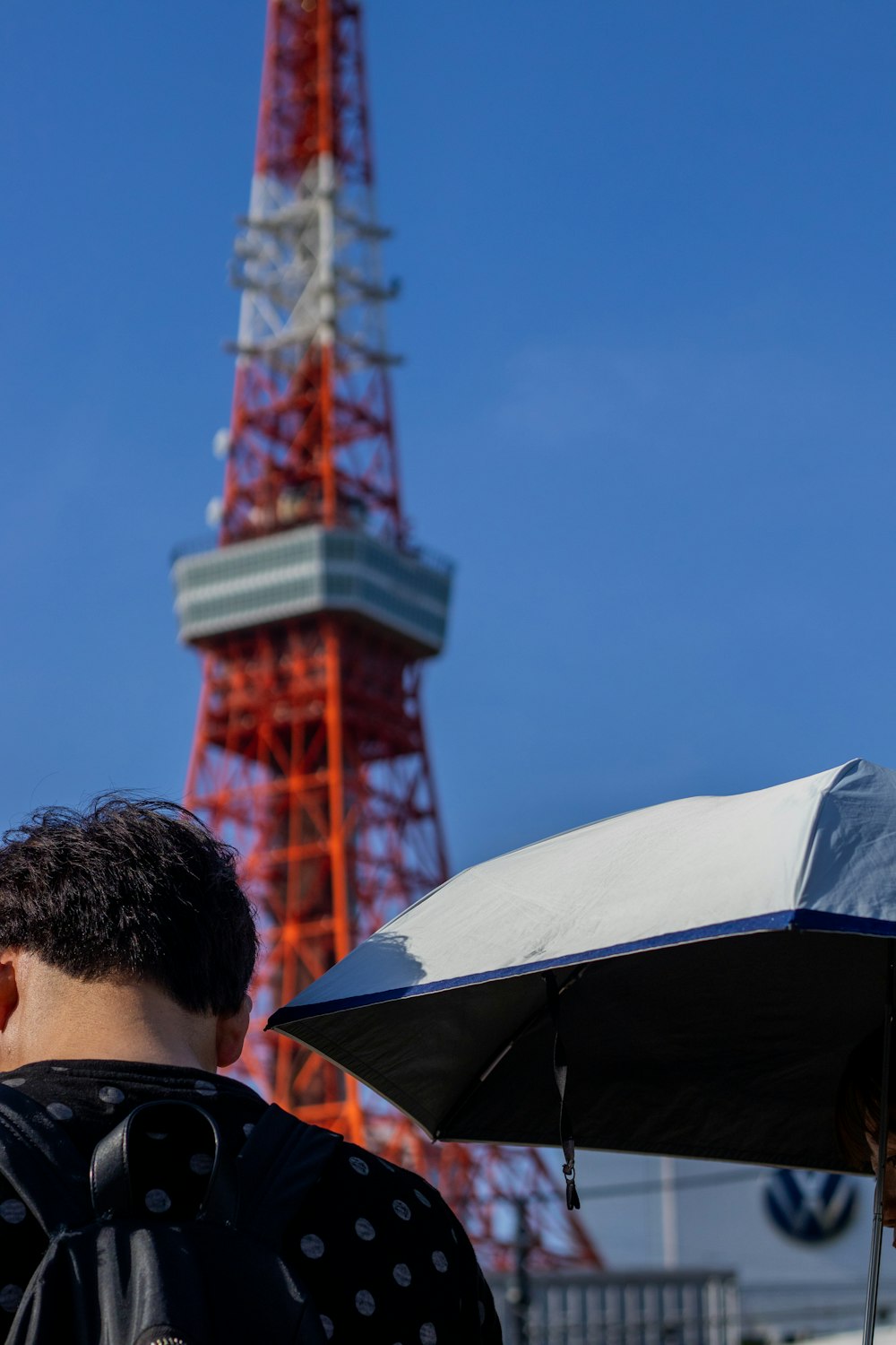 a man holding an umbrella in front of a tower