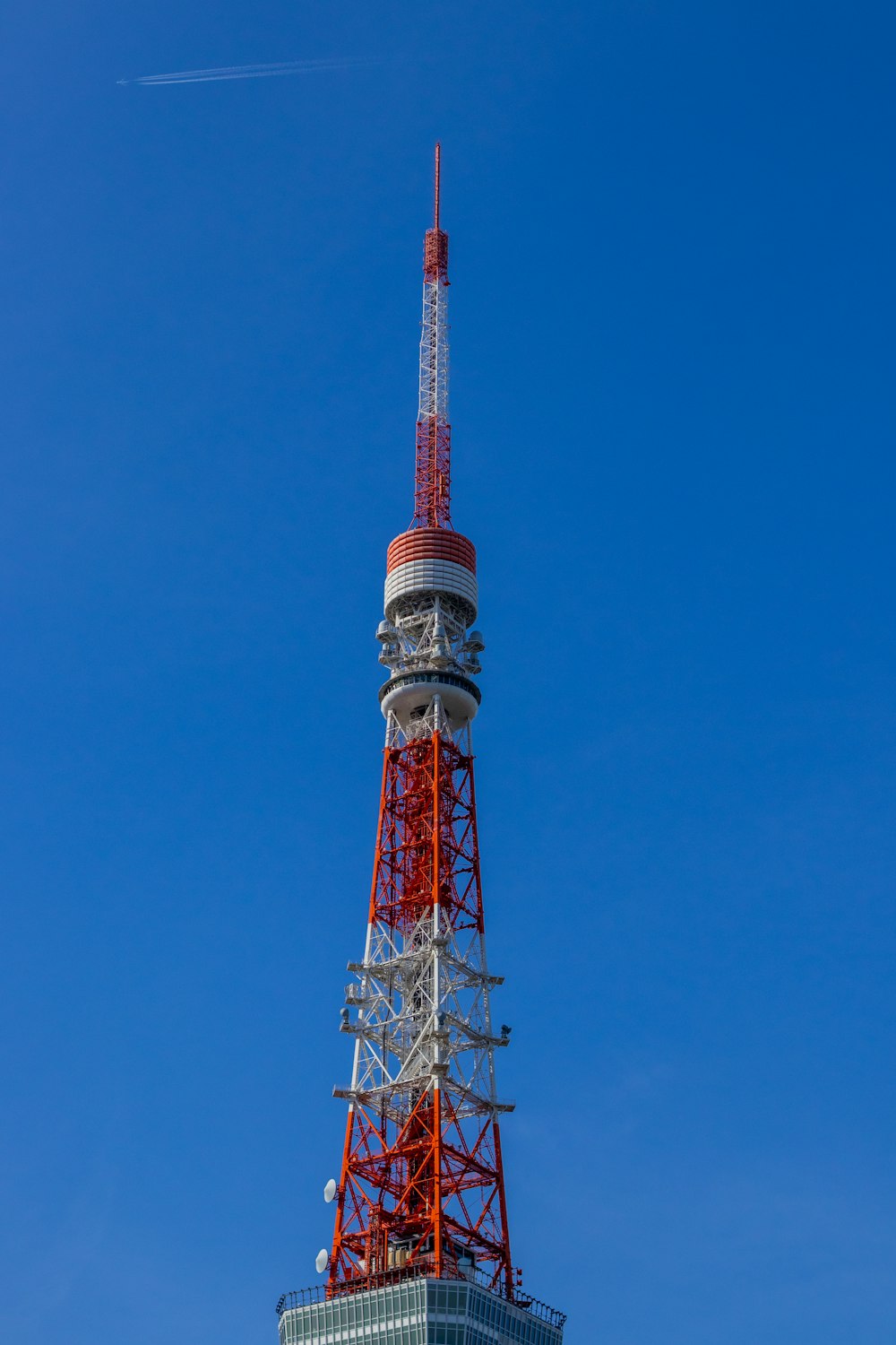 a very tall tower with a red and white top