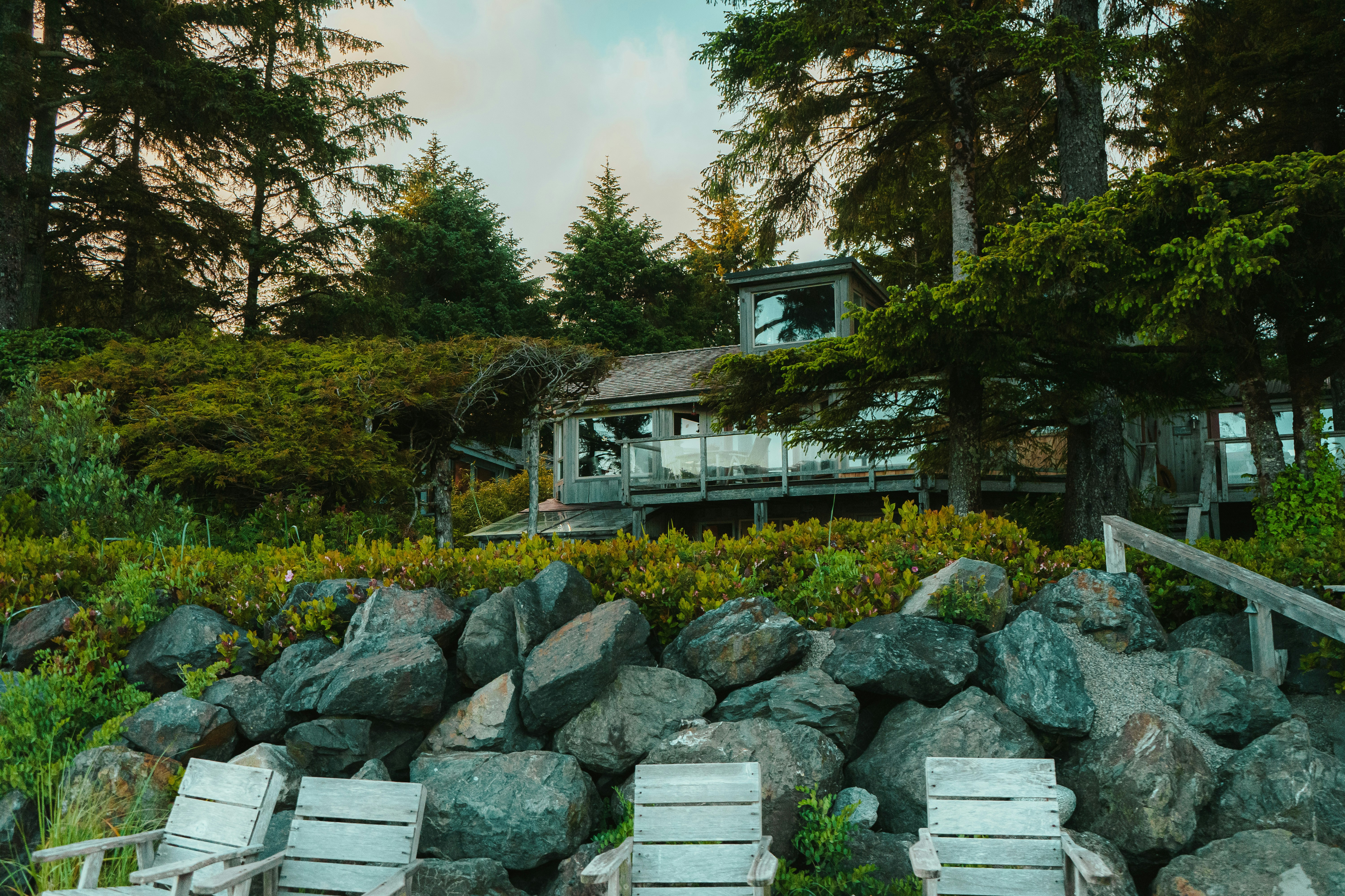 a couple of white chairs sitting on top of a pile of rocks