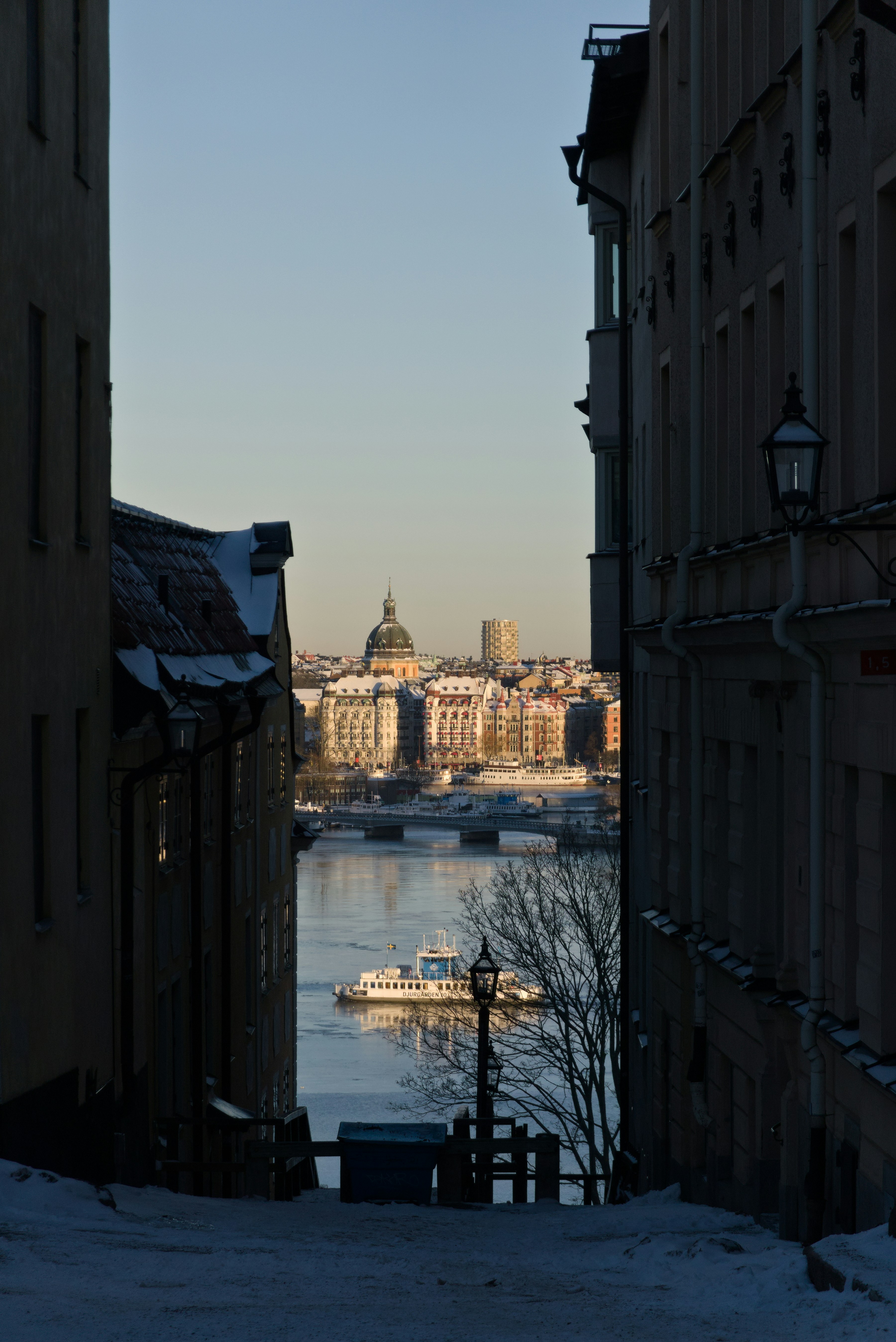 a view of a body of water from between two buildings