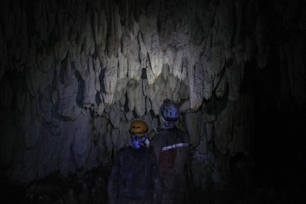 a couple of people standing in a cave