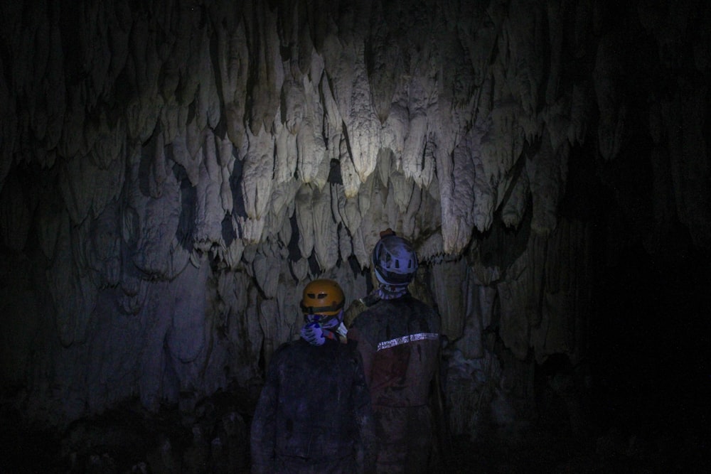 a couple of people standing in a cave