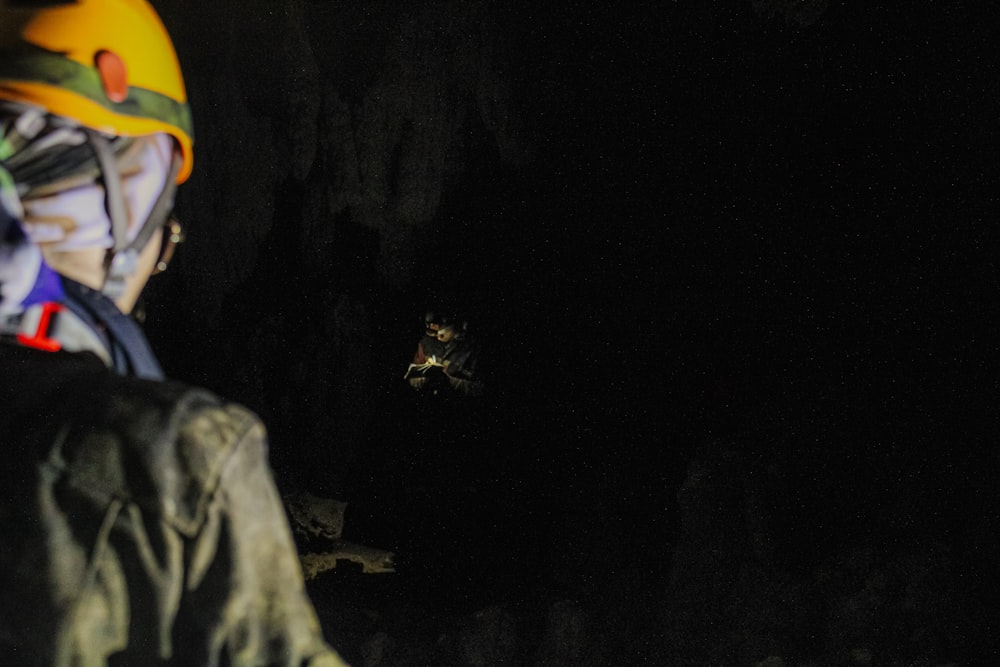 a man wearing a helmet standing in a cave