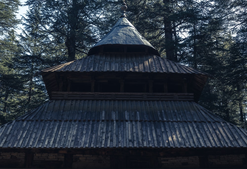 um edifício alto de madeira sentado no meio de uma floresta