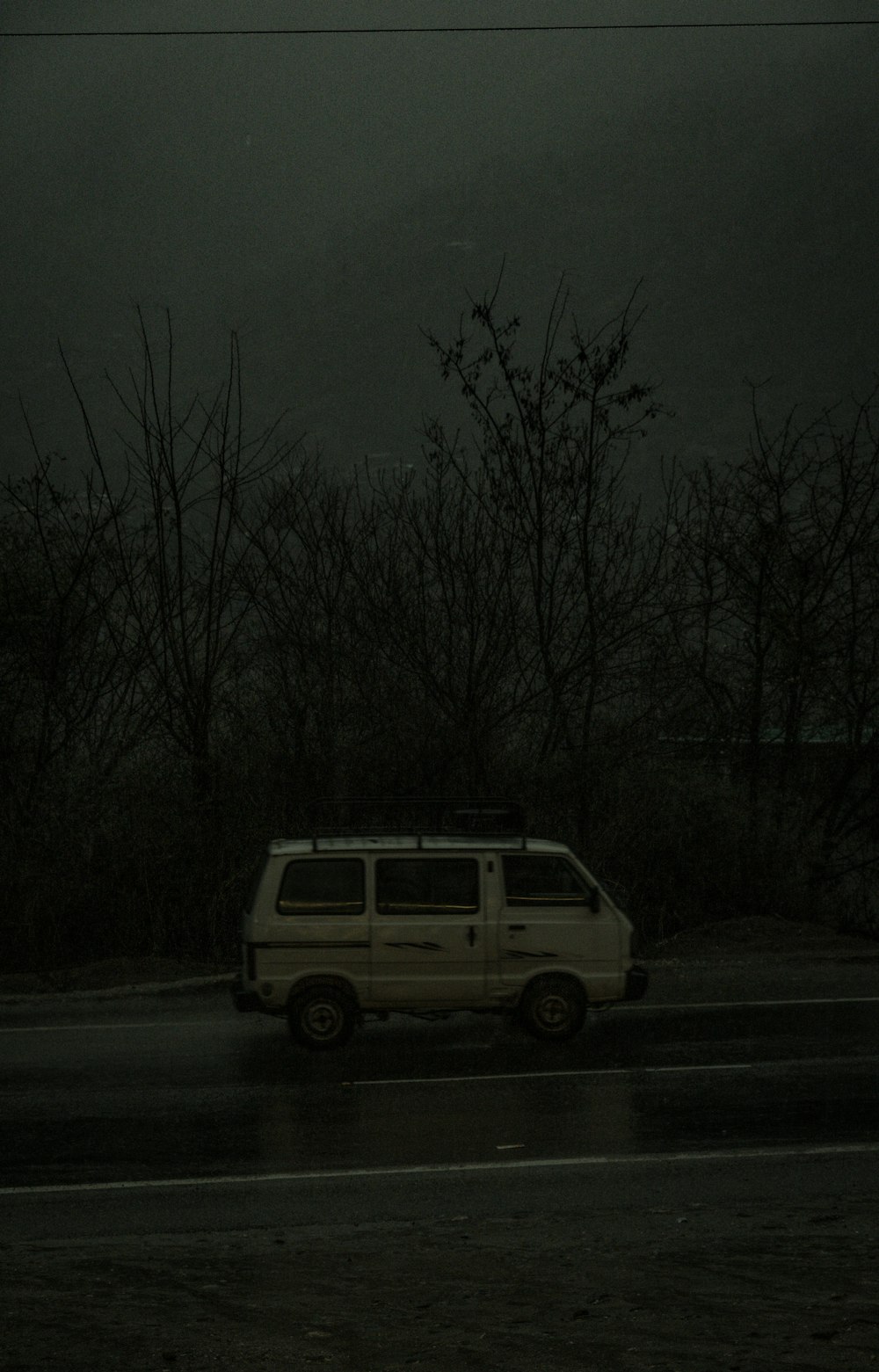 a white van driving down a rain soaked road