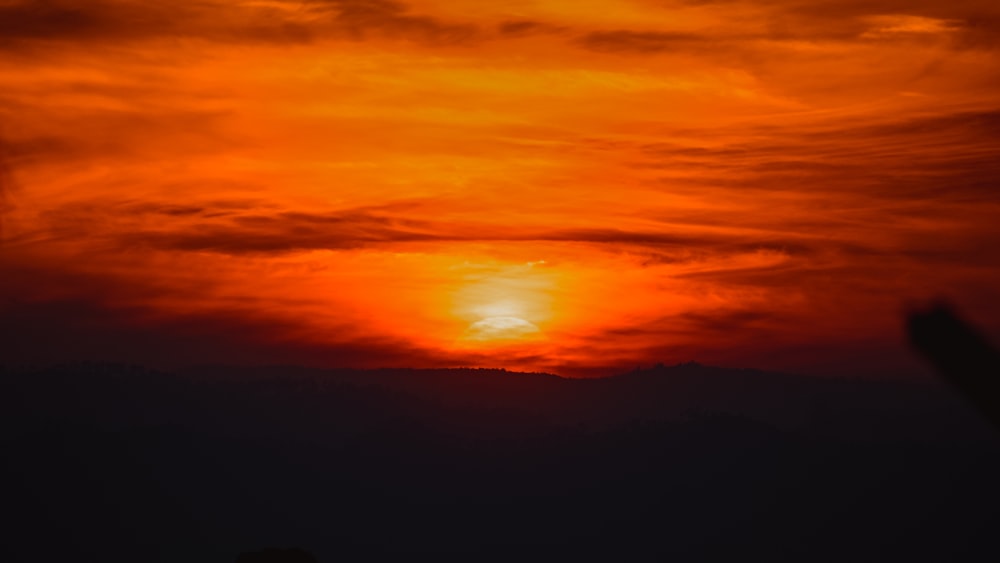 the sun is setting over a mountain range