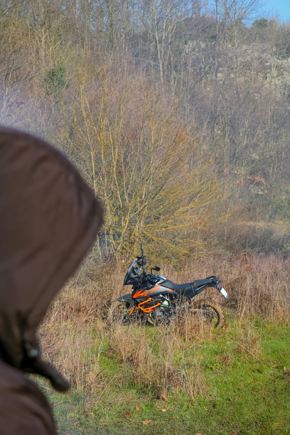 a man standing next to a motorcycle in a field