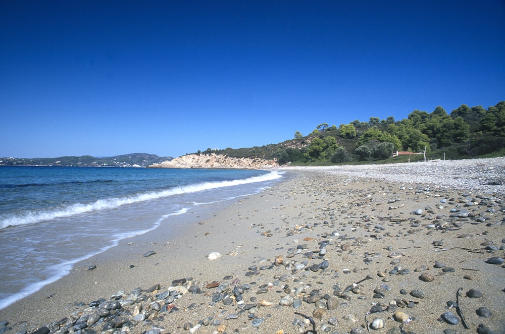 a sandy beach with waves coming in to shore