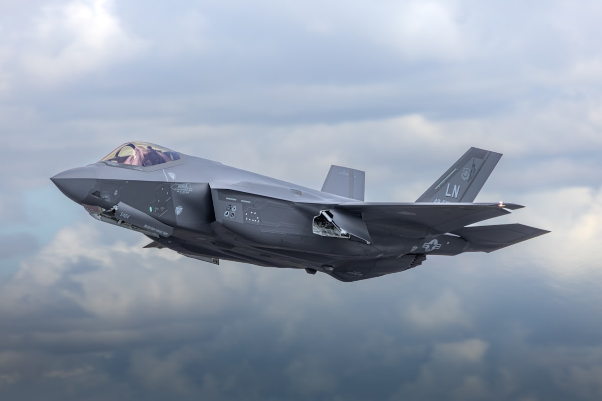 Military fighter jet in flight representing defense contractor industry