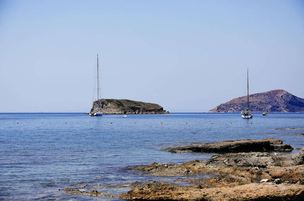 a couple of boats floating on top of a body of water