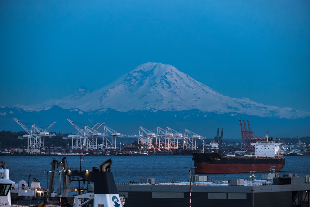 a large mountain is in the background of a body of water