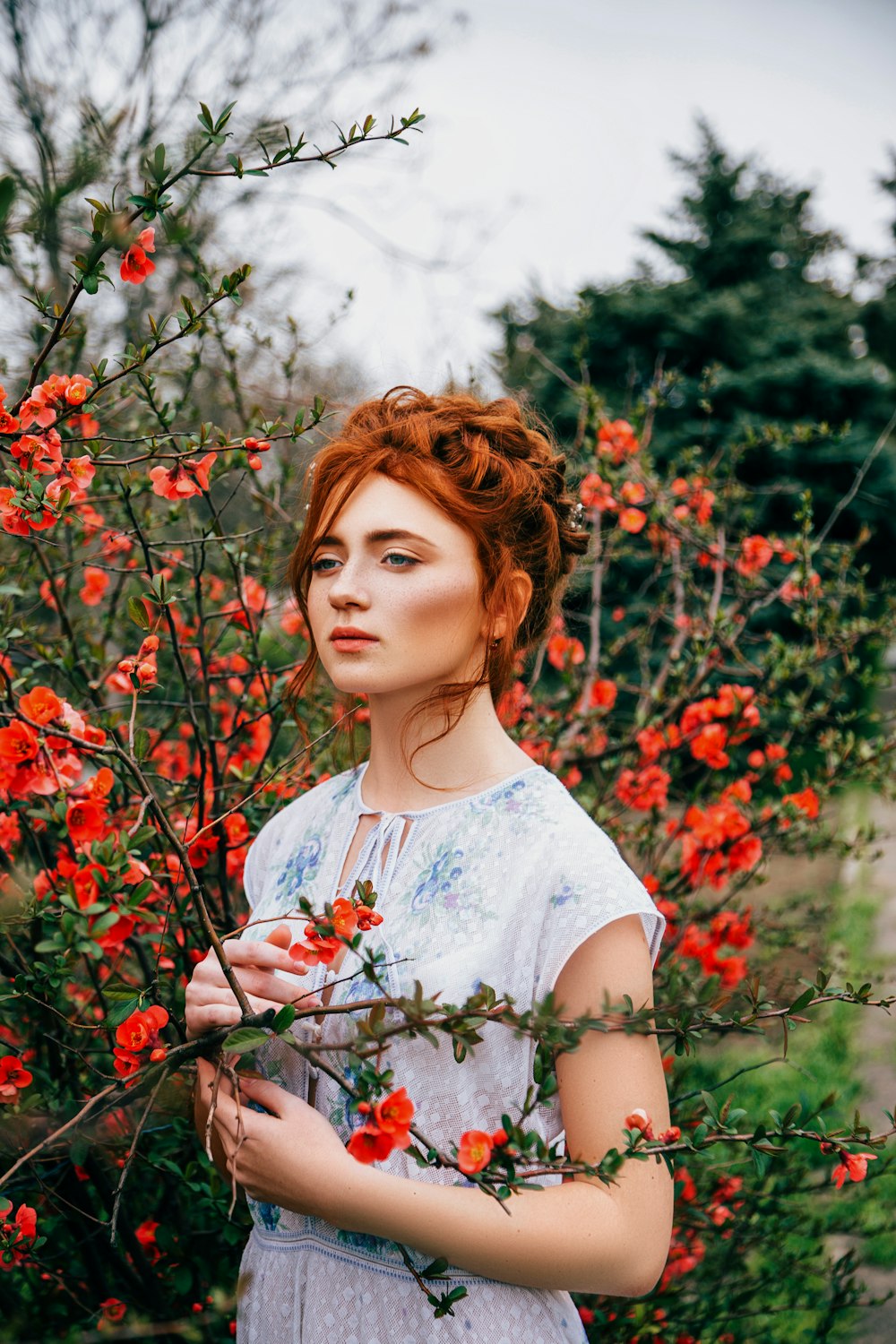 a woman standing in a field of red flowers