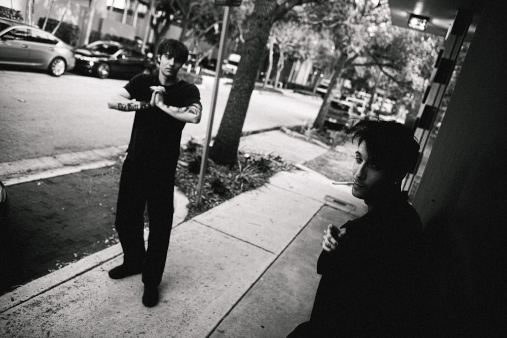 a man standing next to a woman on a sidewalk