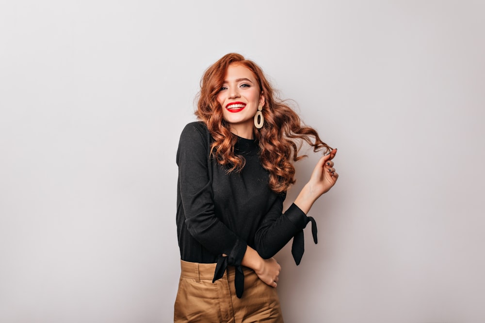 a woman with long red hair and a black shirt
