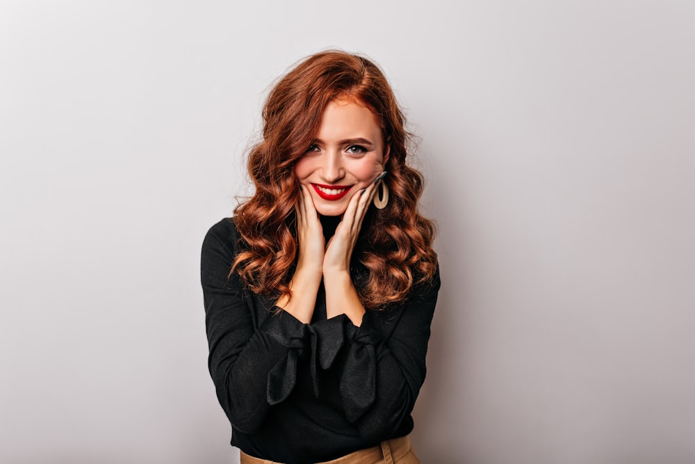 a woman posing for a picture with her hands on her face