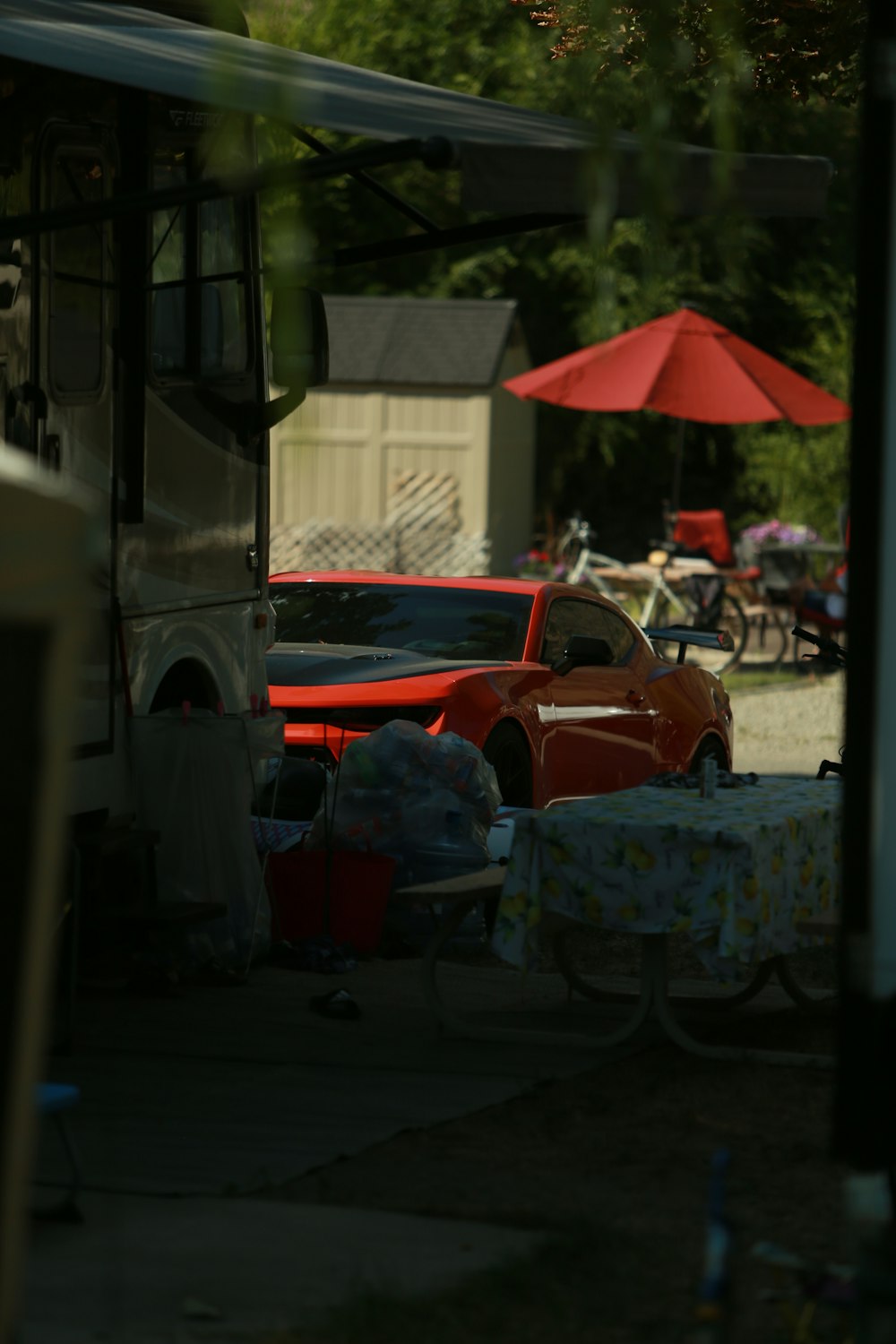 a red car parked next to a red umbrella