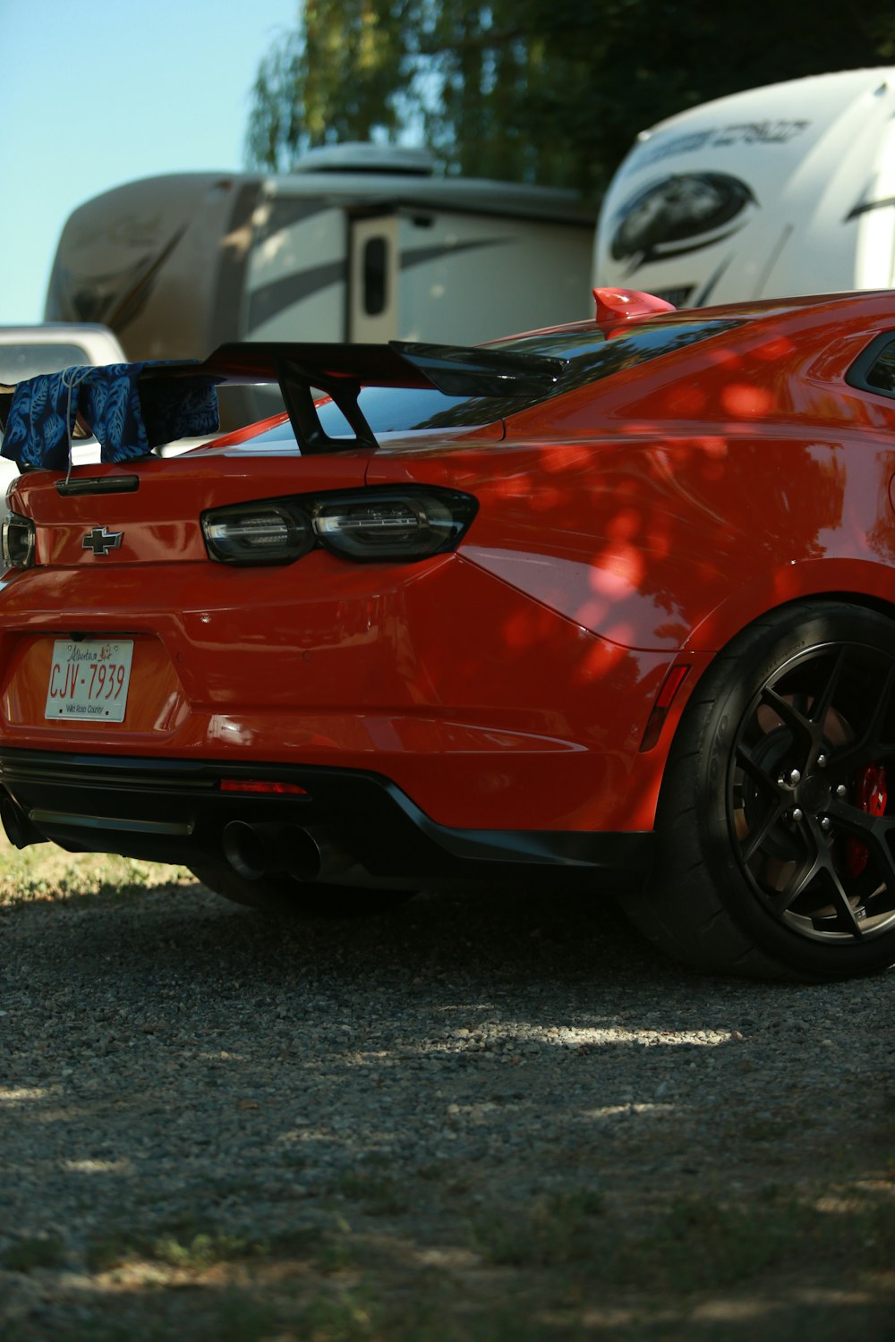 a red sports car parked in front of a trailer