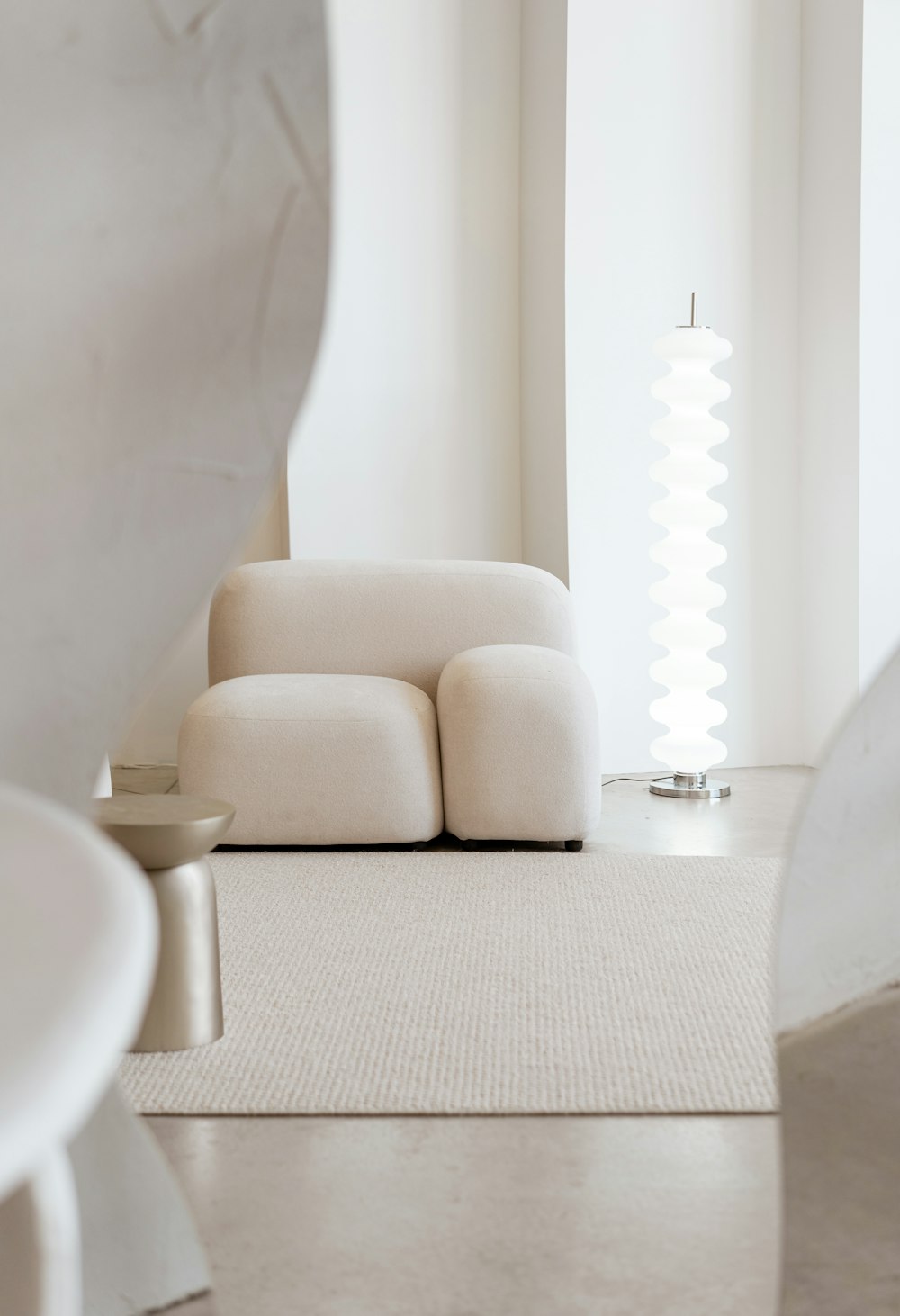 un sofá blanco sentado en una habitación junto a una ventana