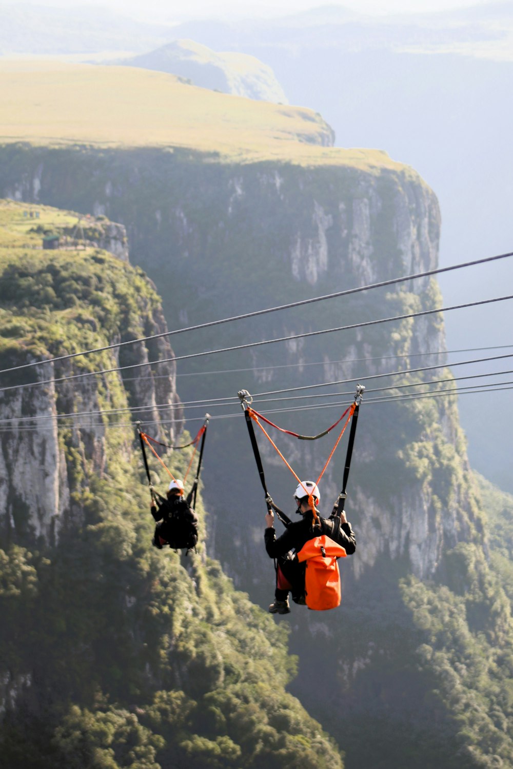 a couple of people riding on top of a zip line